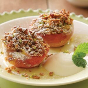 Grilled peaches with berry sauce and pistachio crumble topping