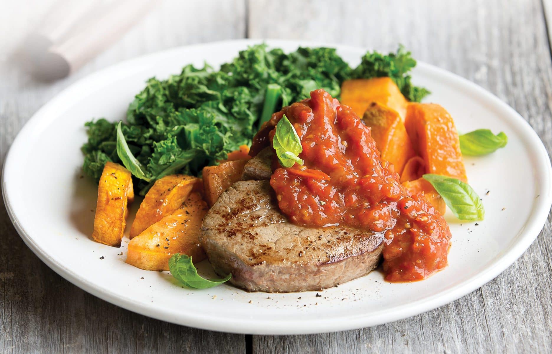 Steak with roasted capsicum, tomato and garlic topping