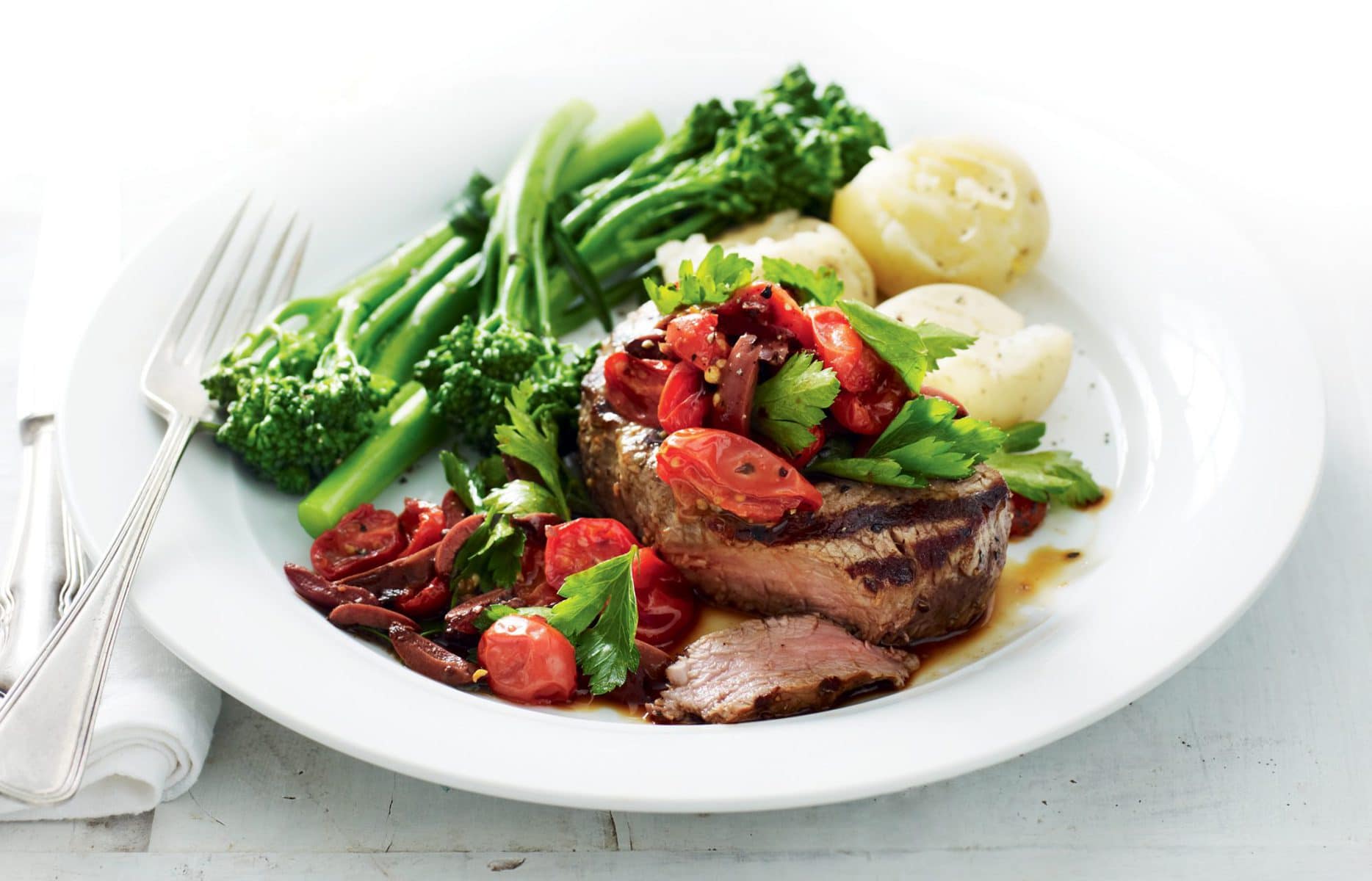 Steak with tomato, olive and parsley relish