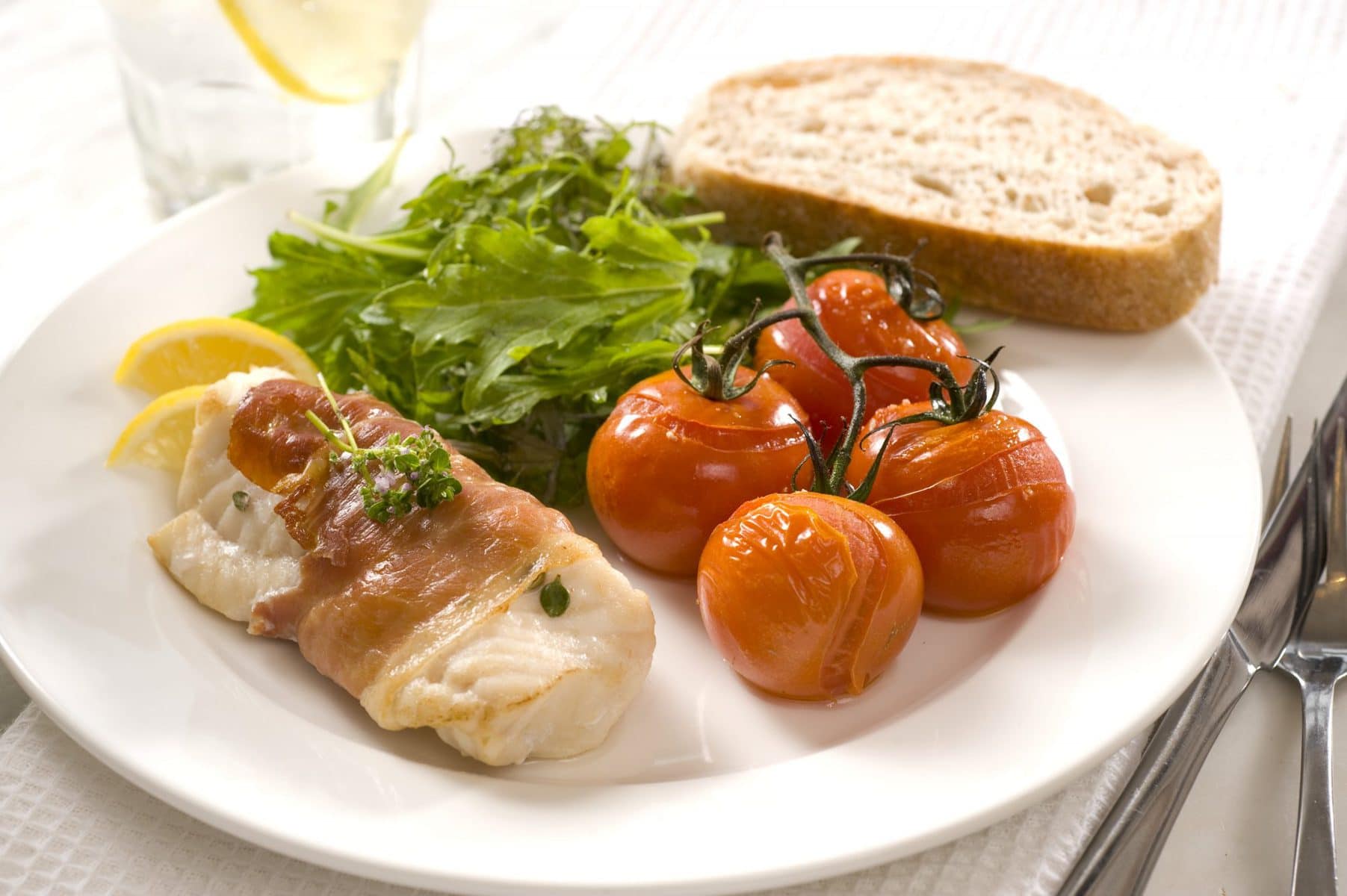 Prosciutto-wrapped fish with roasted vine tomatoes