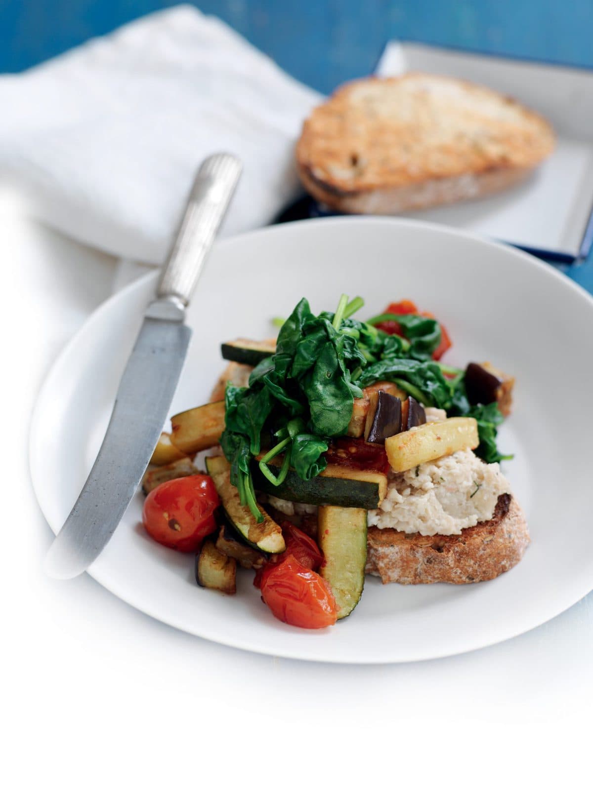 White bean mash with wilted spinach, courgette and tomato
