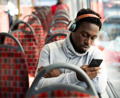 Man on train with headphones and smartphone