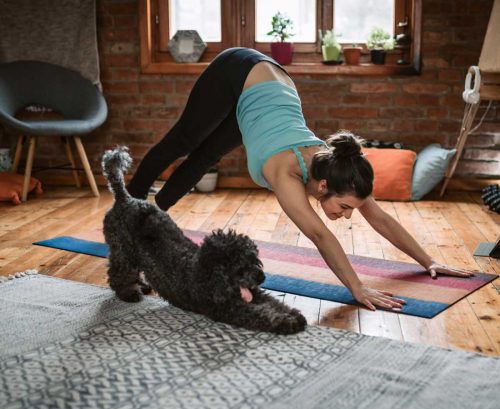 woman and dog doing yoga