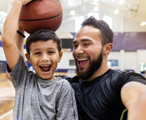 Man and boy laughing with basketball
