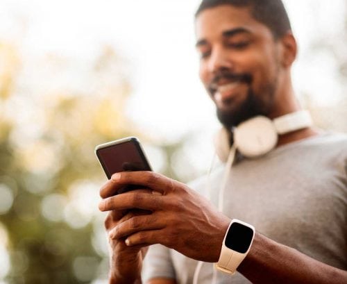 Fit man using smartphone apps
