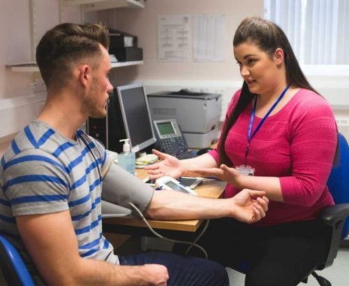 Doctor taking patient's blood pressure