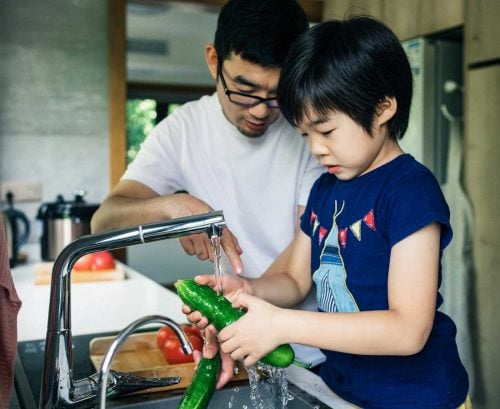 Dad and daighter washing vegetables