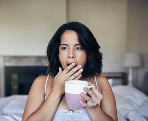 Woman drinking coffee in bed