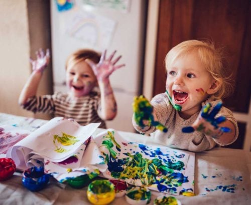 Two small kids finger painting