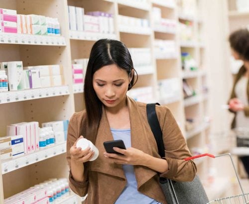 Woman choosing supplements at pharmacy