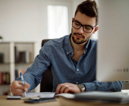 Man in glasses at computer working from home
