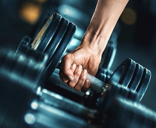 Man reaching for dumbell weight