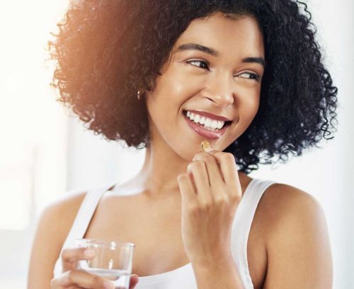 Woman eating a fish oil capsule