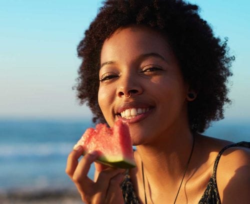 Smiling woman eating watermelon