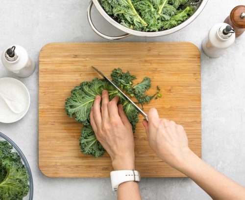 Person chopping kale on a board