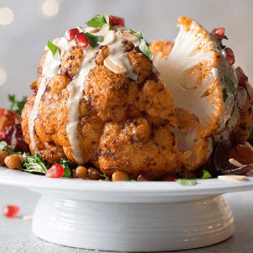 Roasted whole harissa cauliflower, spiced chickpeas and tahini drizzle