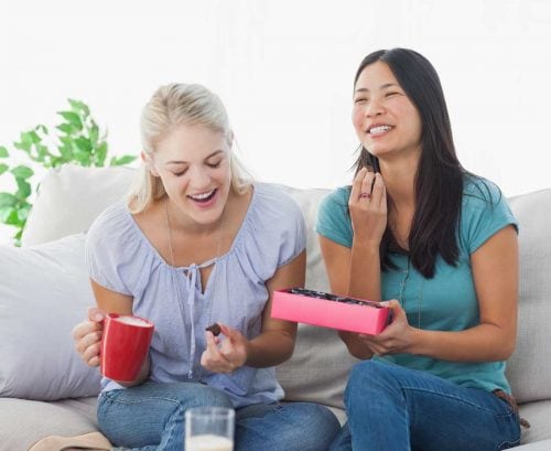 Two women sharing a box of chocolates