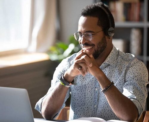 Happy man at work in front of his laptop