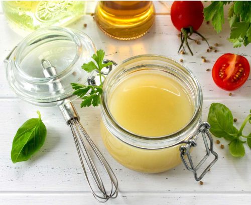 Lemon vinaigrette with tomatoes, basil and a whisk