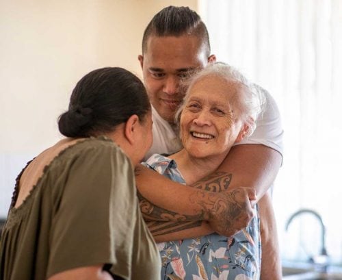Family hugging grandmother