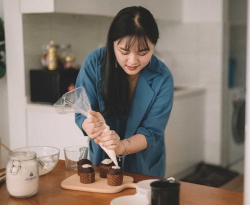 Woman mindfully icing cupcakes