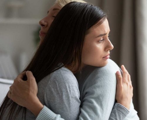 Mother hugging sad daughter