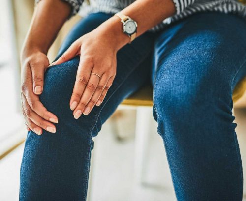 Woman rubbing her sore knee