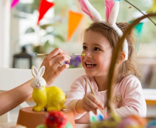 Girl with Easter bunny ears on making crafts