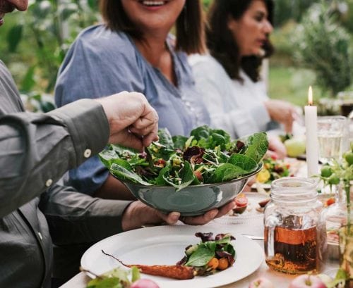 Dinner party with lots of vegetables being passed around