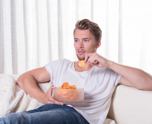 Man eating salty chips or crisps