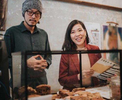 Man and woman ordering food at a cafe counter