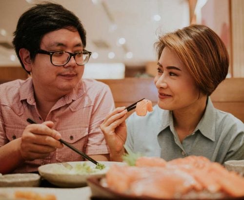 Couple eating salmon sashimi