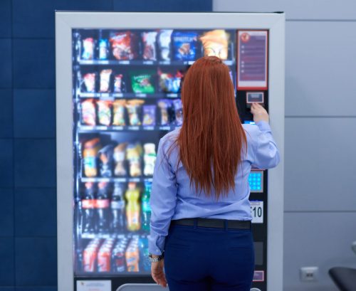 Person choosing snacks from a vending machine