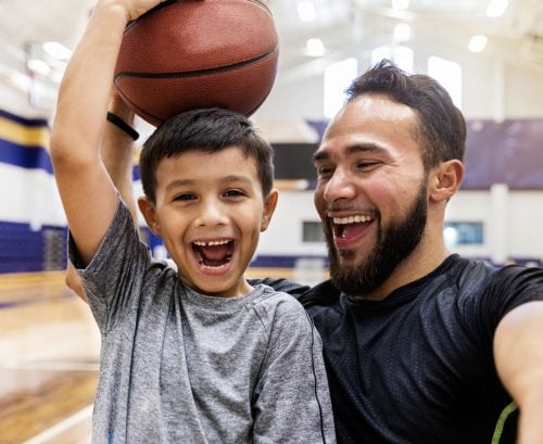Happy father and son playing with a basketball