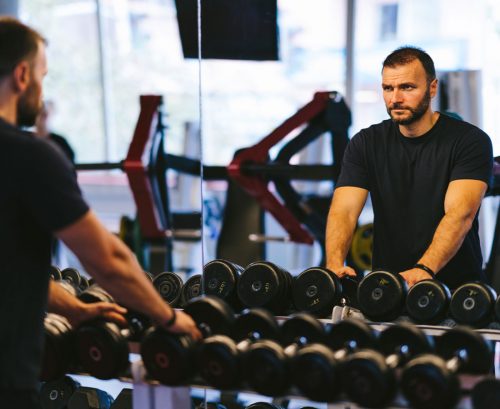 Man looking at himself in the mirror at the gym