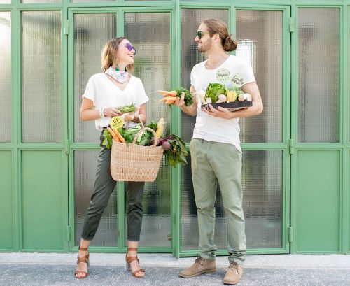 vegan couple standing together with their grocery shopping