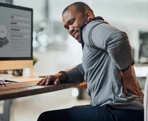 Man at his computer with back pain