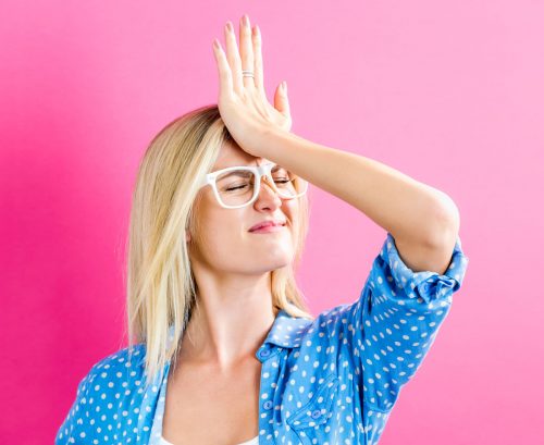 Woman face-palming her forehead after making a mistake