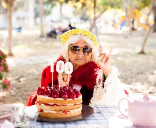 Woman in sunglasses celebration 100th birthday with cake