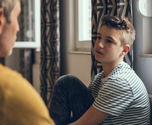 Father talking to sad son