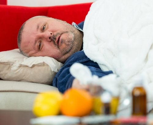 Man in bed on couch with COVID