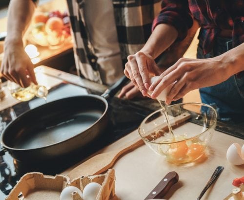 Two people cooking an omelette