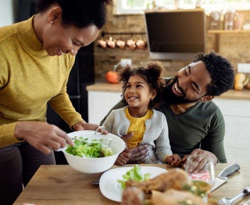 Woman serving food to daughter and partner