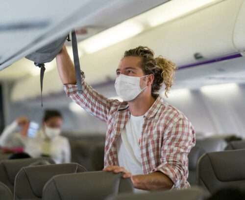 Man placing bag in baggage hold ion a plane