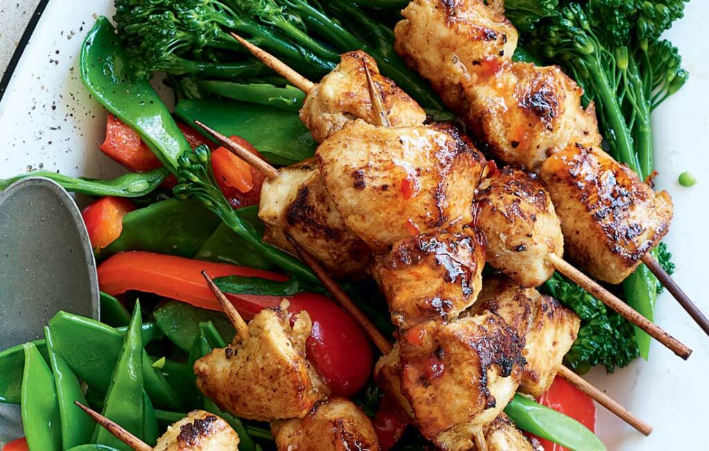 Sticky chicken skewers with stir-fried greens