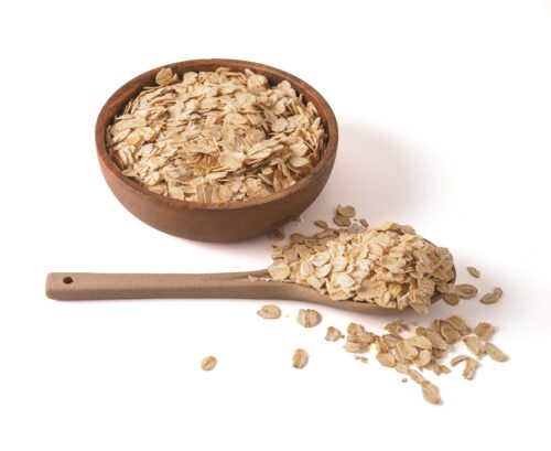 Gluten free wholegrain oat flakes in wooden bowl. - gluten-free swaps