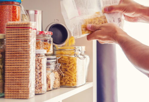 An image of a man's hands tidying their pantry cupboard